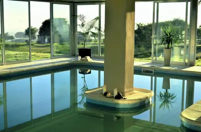 a large building with a swimming pool with windows at Howard Johnson Hotel Piedras Moras in Almafuerte