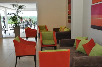 a living room with colorful chairs and a couch at Howard Johnson Hotel Piedras Moras in Almafuerte