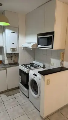 a kitchen with a washing machine and a microwave at Oak Home en Nva Cba in Cordoba