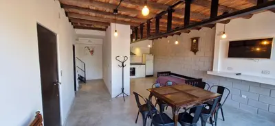 a dining room with a wooden table and chairs at Vivisierras, Duplex de categoría centro Carlos Paz vista frente al lago, 3 dormitorios, 2 baños, acceso inteligente in Villa Carlos Paz