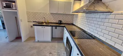 a small kitchen with white cabinets and a sink at Vivisierras, Duplex de categoría centro Carlos Paz vista frente al lago, 3 dormitorios, 2 baños, acceso inteligente in Villa Carlos Paz