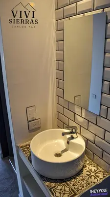 a bathroom with a sink and a mirror at Vivisierras, Duplex de categoría centro Carlos Paz vista frente al lago, 3 dormitorios, 2 baños, acceso inteligente in Villa Carlos Paz