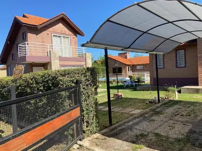 a large umbrella over a fence in front of a house at Cabañas Abril in Merlo