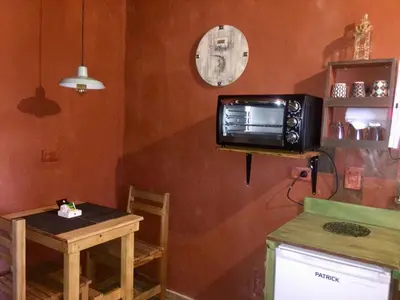 a kitchen with a table and a microwave on a wall at Cabañas La Ruka in Los Reartes