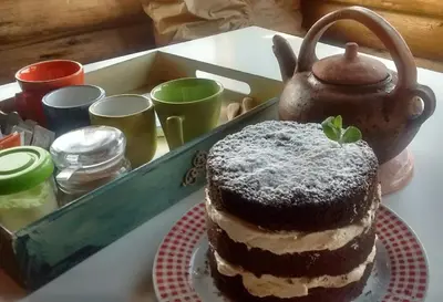 a cake sitting on a table next to a tea pot at Cabañas La Ruka in Los Reartes
