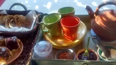 a tray of food with cups of tea and desserts at Cabañas La Ruka in Los Reartes