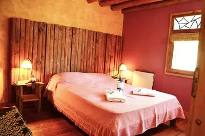 a bedroom with a bed with two towels on it at Cabañas La Ruka in Los Reartes