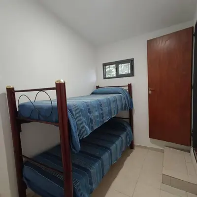 a bedroom with two bunk beds and a door at Excepcional Casa de campo in Villa Anizacate