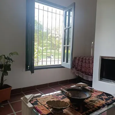 a living room with a table and a window at Excepcional Casa de campo in Villa Anizacate