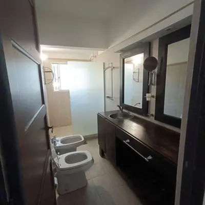 a bathroom with two toilets and a sink and a mirror at Excepcional Casa de campo in Villa Anizacate