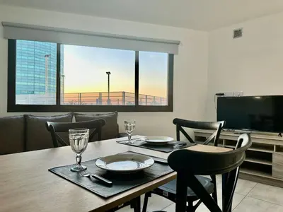a dining room with a table and a television at FTE HOTEL QUINTO CENTENARIO NUEVOCENTRO shopping LUMINOSO DTO EXCELENTE VISTA 1 dor in Cordoba