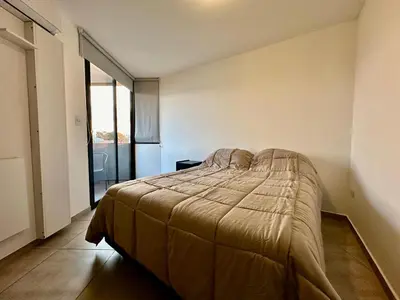 a bedroom with a bed with a blanket on it at FTE HOTEL QUINTO CENTENARIO NUEVOCENTRO shopping LUMINOSO DTO EXCELENTE VISTA 1 dor in Cordoba