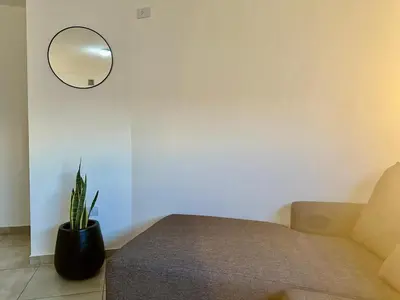 a room with a couch and a mirror and a plant at FTE HOTEL QUINTO CENTENARIO NUEVOCENTRO shopping LUMINOSO DTO EXCELENTE VISTA 1 dor in Cordoba