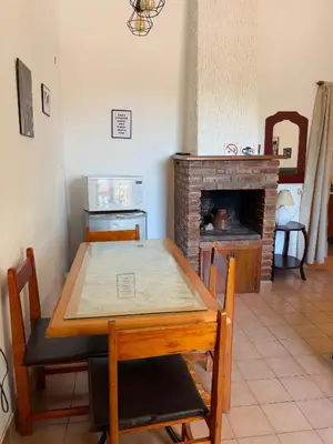 a dining room with a table and a fireplace at Departamentos Pasini in Villa Carlos Paz
