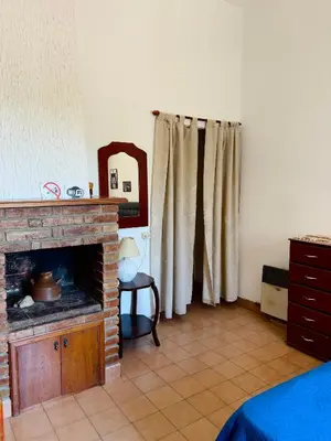 a living room with a fireplace and a mirror at Departamentos Pasini in Villa Carlos Paz