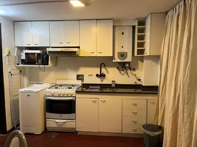 a kitchen with white cabinets and a stove top oven at Departamento en el centro in Cordoba