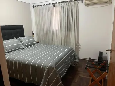 a bedroom with a bed with striped sheets and a window at Departamento en el centro in Cordoba