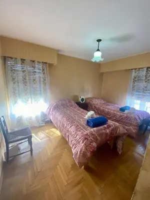 a bedroom with two beds and a chair at Julia Apparts - DEPARTAMENTO EN EL CENTRO DE LA CIUDAD in Cordoba