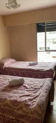 two beds in a bedroom with a window at Julia Apparts - DEPARTAMENTO EN EL CENTRO DE LA CIUDAD in Cordoba