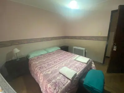 a bedroom with a bed and a blue chair at Julia Apparts - DEPARTAMENTO EN EL CENTRO DE LA CIUDAD in Cordoba