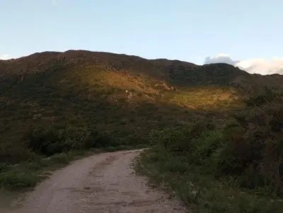a dirt road in front of a mountain at la balsa in Mina Clavero