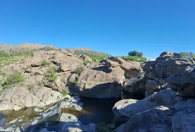 a group of rocks with a stream of water at la balsa in Mina Clavero