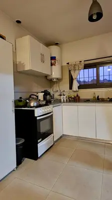 a kitchen with white cabinets and a stove top oven at Casa Safari en La Paisanita, Alta Gracia in Alta Gracia