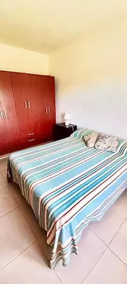a large bed in a room with red cabinets at Casa Safari en La Paisanita, Alta Gracia in Alta Gracia
