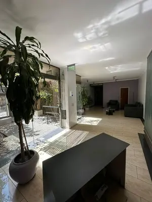a living room with a table and a potted plant at Departamento 1 dorm con cochera Nueva Córdoba 1 E INVERHOME INMOBILIARIA in Cordoba