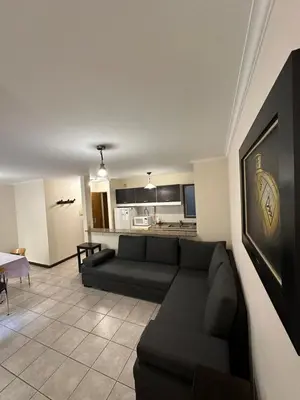 a living room with a couch and a kitchen at Departamento 1 dorm con cochera Nueva Córdoba 1 E INVERHOME INMOBILIARIA in Cordoba