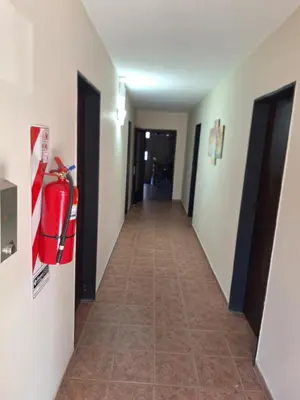 a hallway of a hotel with a fire extinguisher on the wall at Hospedaje Champaqui in Santa Rosa de Calamuchita