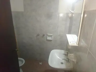 a bathroom with a sink and a mirror and a toilet at Hospedaje Champaqui in Santa Rosa de Calamuchita