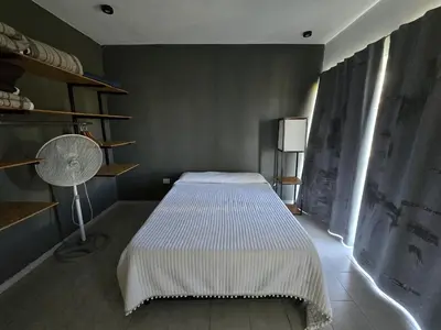 a bedroom with a bed and a lamp and a fan at Vistas360carlospaz in Villa Carlos Paz