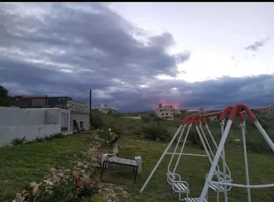 a swing set in a field with a cloudy sky at Vistas360carlospaz in Villa Carlos Paz