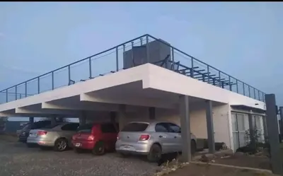 a parking lot with cars parked in front of a building at Vistas360carlospaz in Villa Carlos Paz