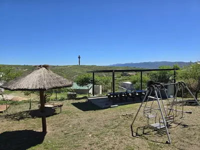 a playground with a swing and an umbrella at Vistas360carlospaz in Villa Carlos Paz
