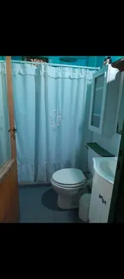 a bathroom with a white shower curtain and a toilet at Casita en Los Hornillos in Los Hornillos