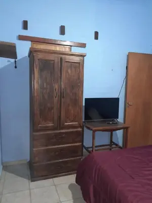 a wooden cabinet with a desk next to a bed at Casita en Los Hornillos in Los Hornillos