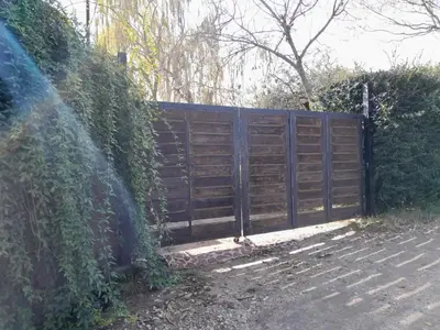 a fence with a wooden gate on the side of a road at Casita en Los Hornillos in Los Hornillos