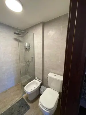 a bathroom with a toilet and a glass shower at Depto 
