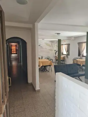 a hallway with tables and chairs in a building at Hostería Los Sauces in Mina Clavero