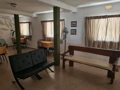 a living room with a bench and a table at Hostería Los Sauces in Mina Clavero