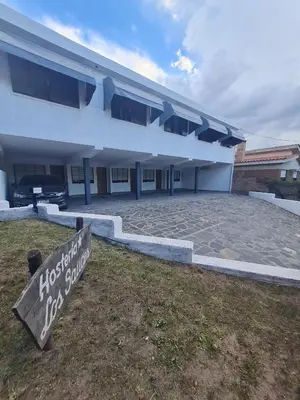 a house with a sign in front of it at Hostería Los Sauces in Mina Clavero