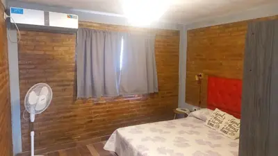 a bedroom with a bed and a window with a fan at Complejo soñado in Mina Clavero