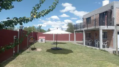 a patio with an umbrella in the yard of a house at Complejo soñado in Mina Clavero