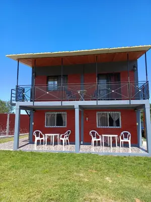 a red building with chairs in front of it at Complejo soñado in Mina Clavero
