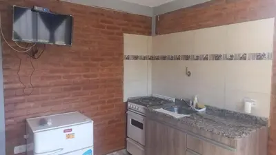 a kitchen with a stove and a sink and a tv at Complejo soñado in Mina Clavero