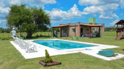 a man standing next to a swimming pool next to a house at Holiday Home Alta Vista in Mina Clavero