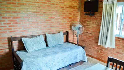 a bedroom with a bed and a brick wall at Holiday Home Alta Vista in Mina Clavero