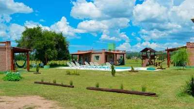 a yard with a playground with chairs and a house at Holiday Home Alta Vista in Mina Clavero